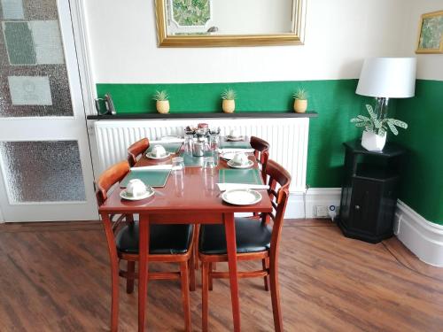 uma sala de jantar com uma mesa e quatro cadeiras em Birchhouse em Blackpool