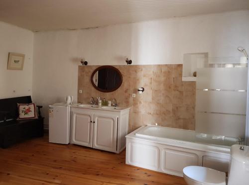 Baño blanco con bañera y lavamanos en Maison du Coquelicot, en Tourouzelle