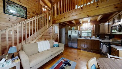 a living room with a couch and a kitchen at Yellow Cabin on the River cabin in Newport