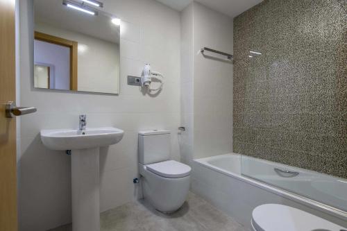 a bathroom with a toilet and a sink and a mirror at Apartamento centro histórico en Manresa in Manresa