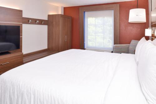 a bedroom with a large white bed and a television at Holiday Inn Express Towson- Baltimore North by IHG in Towson