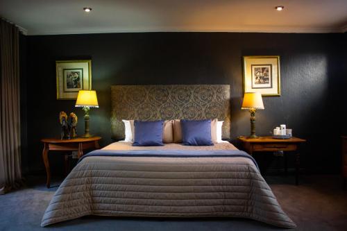 a bedroom with a large bed with blue pillows at Koru Guesthouse in Pretoria