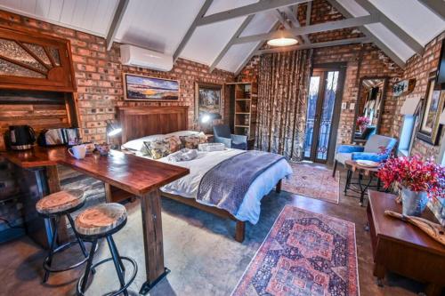 a bedroom with a bed and a brick wall at Upper Room @thegallery in Bloemfontein