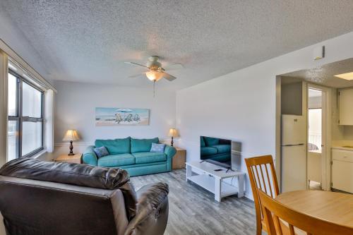 a living room with a blue couch and a table at Coastal Waters in New Smyrna Beach