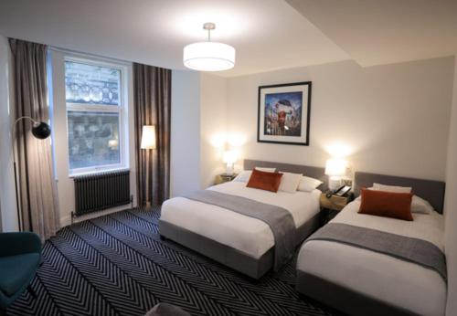 a hotel room with two beds and a window at Boutique 50 in Glasgow