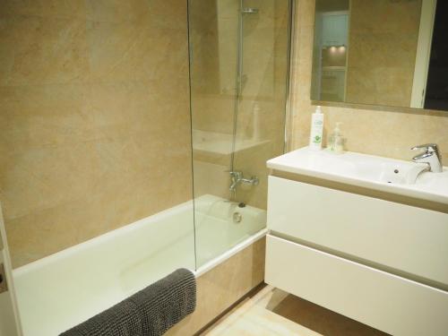 a bathroom with a tub and a sink and a shower at Apartament per families a Sant Feliu amb piscina in Sant Feliu de Guixols