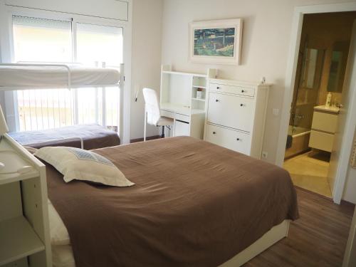 a bedroom with two beds and a desk and a desk at Apartament per families a Sant Feliu amb piscina in Sant Feliu de Guixols