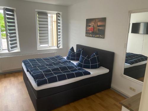 een slaapkamer met een bed met blauwe lakens en kussens bij Mitten im Herzen von Neubrandenburg in Neubrandenburg