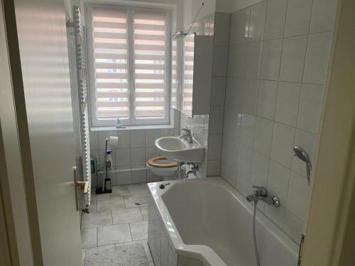 een witte badkamer met een bad en een wastafel bij Mitten im Herzen von Neubrandenburg in Neubrandenburg