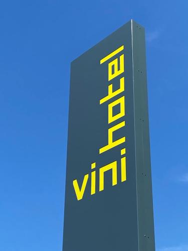 a sign on the side of a building with yellow writing at Vini Hotel in Beaune