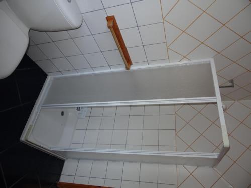 a white shelf in a bathroom with white tiles at Casa da Alícia in Feiteira