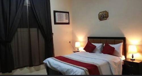 1 dormitorio con 1 cama grande con almohadas rojas en شقق قمة الرفاء للوحدات السكنيه, en Riad