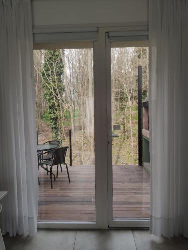 an open sliding glass door with a table on a deck at Del arroyo Tandil in Tandil