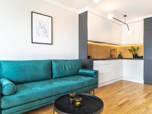 a living room with a green couch and a table at City View Apartment - Zgoda 13 in Warsaw