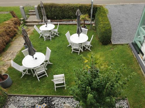 a group of tables and chairs on the grass at Ferienwohnung in einem alten Bauernhaus in Lontzen