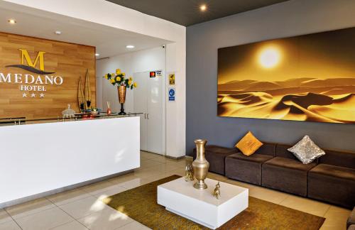 a lobby of a hotel with a couch and a counter at Hotel Médano in Trujillo