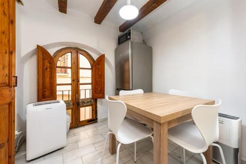 eine Küche mit einem Holztisch und weißen Stühlen in der Unterkunft Hauzify I Domus Tarragona in Tarragona