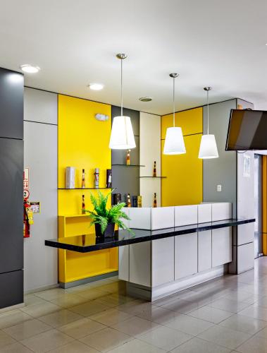a kitchen with yellow walls and a black counter at Hotel Médano in Trujillo