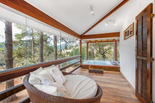 um quarto com uma cama numa varanda com uma banheira em Pousada Lago dos Sonhos em Piracaia