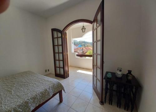 1 dormitorio con 1 cama y puerta abierta en Casa de Praia Ibicuí, en Mangaratiba
