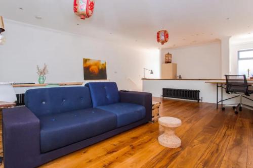 a living room with a blue couch and a table at Cosy 2 Bedroom Apartment with Great Outdoor Balcony in London