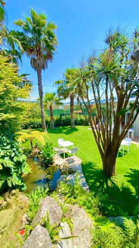a garden with a picnic table and palm trees at Hotel Combarro in Combarro