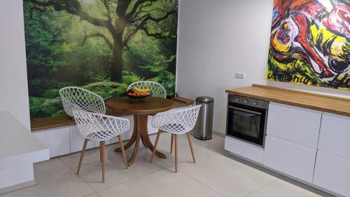 a kitchen with a table and chairs and a painting at Club Dres in Bockau