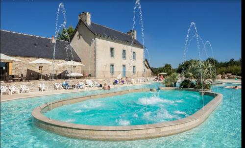 a pool with a fountain in front of a building at Royal Castel mobile home in Quimper
