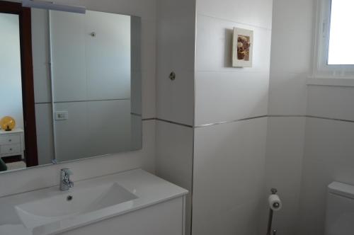 a white bathroom with a sink and a mirror at Fantástica vista de la Ría de Vigo en pleno centro in Vigo