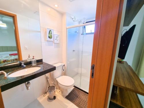 a bathroom with a toilet and a sink and a shower at Apartamento Paraiso do Pontal in Ilhéus