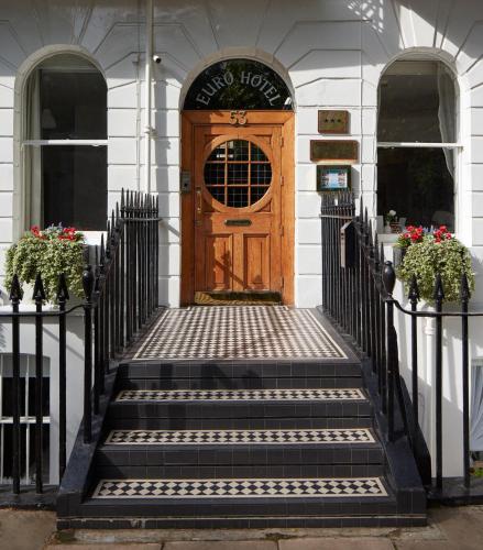 a wooden door with stairs in front of a building at Euro Hotel in London