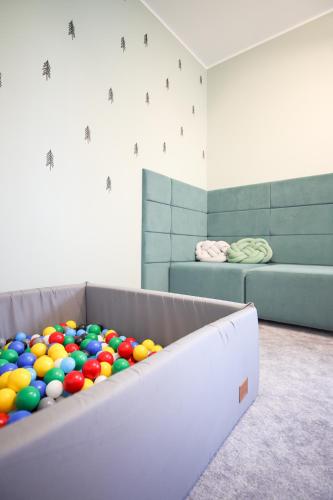 a pile of balls on a couch in a room at Apartamenty Augustynówka in Brzegi