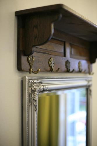 a mirror with a wooden frame on a wall at Kamienica Boutique ApartHotel in Białystok