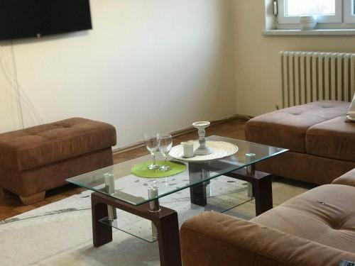 een woonkamer met een glazen tafel en een bank bij Tresnja in Banja Luka