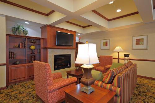 a living room with a couch and chairs and a fireplace at Spark by Hilton Washington Meadowlands Blvd in Washington
