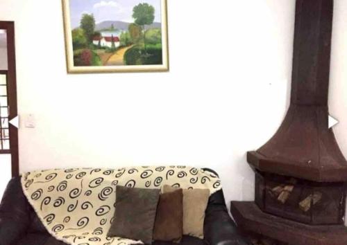 a living room with a couch and a fireplace at Chácara espaçosa e aconchegante em Juquitiba Sp in Juquitiba