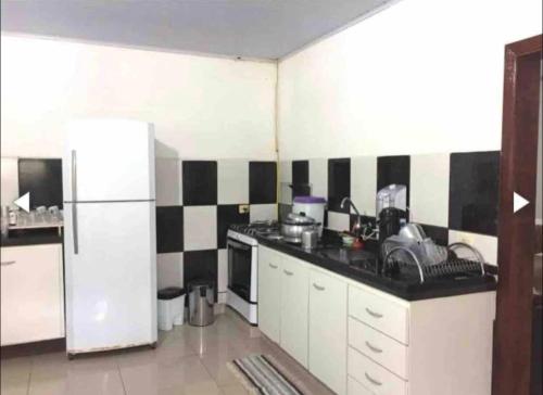 a kitchen with a black and white tiled wall at Chácara espaçosa e aconchegante em Juquitiba Sp in Juquitiba
