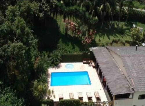 an overhead view of a swimming pool next to a house at Chácara espaçosa e aconchegante em Juquitiba Sp in Juquitiba