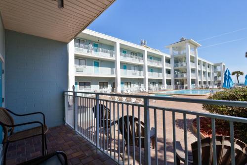 a balcony of a hotel with chairs and a pool at Coastal Waters in New Smyrna Beach