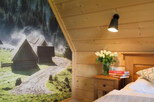 a bedroom with a wall mural of a village at Apartamenty Augustynówka in Brzegi