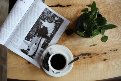 a book and a cup of coffee on a table at Apartamenty Augustynówka in Brzegi