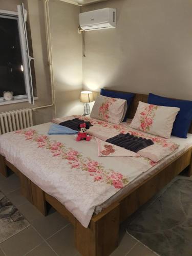 Una cama grande con flores en una habitación en Guest House Jasmin, en Niška Banja