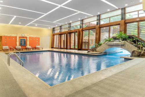 a large swimming pool in a large building with a pool at Swissotel Quito in Quito
