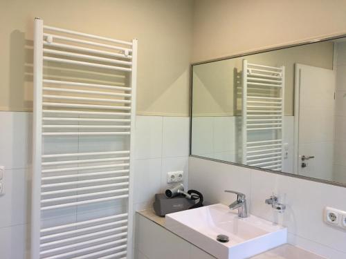 a bathroom with a sink and a mirror at KOMPLETTES FERIENHAUS POTSDAM BERLIN GÄSTEHAUS IN SEENÄHE 95qm2 MONTEURZIMMER in Potsdam