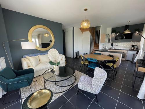 ein Wohnzimmer mit Sofa, Stühlen und einem Tisch in der Unterkunft superbe villa au pied de Disneyland et val d'Europe in Serris