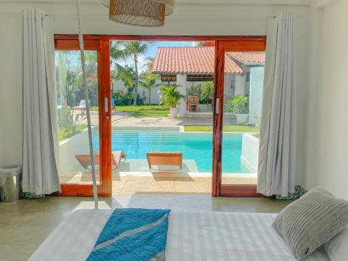 een slaapkamer met een deur naar een zwembad bij Kite Soul Pousada in Cumbuco