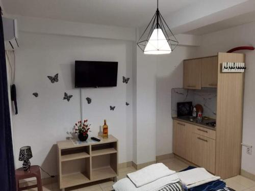 a living room with a kitchen with a tv on the wall at Vera Apartments in Ohrid