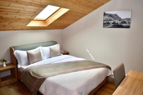 um quarto com uma cama grande e uma clarabóia em Alis Hotel em Shkodër