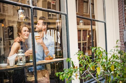 a man and woman looking in the window of a store at Mister Highland Hotel in Amsterdam