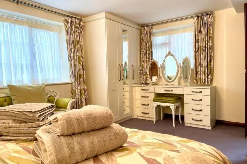 a bedroom with a bed and a vanity and mirrors at Adorable 2 bedroom countryside guesthouse in Broom
